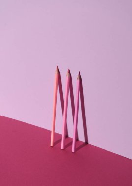 Gölgeli üç pembe renkli kalem. Yaratıcı yerleşim