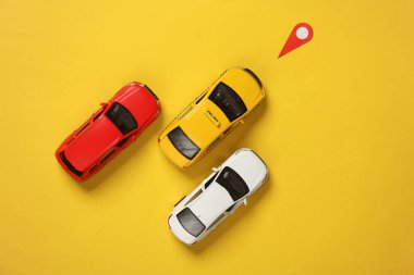 Sarı arka planda konum işaretli araba modelleri