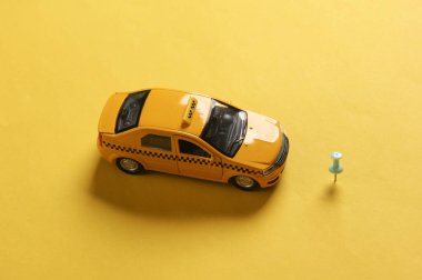 Sarı arka planda iğnesi olan bir araba modeli. Yer belirleme, GPS, navigasyon. Düz yatıyordu