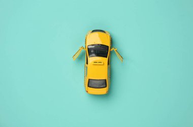 Mavi arka planda oyuncak taksi modeli üst görünümü