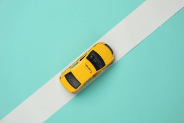 Mavi arka planda beyaz bantlı oyuncak taksi modeli