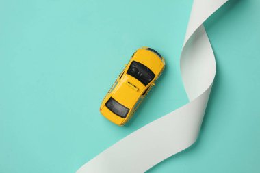 Mavi arka planda çek bandı olan oyuncak taksi modeli. Üst görünüm