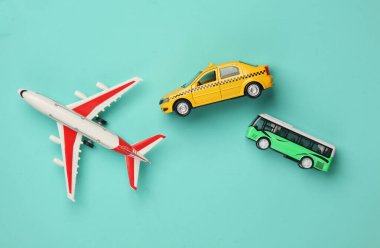 Mavi arka planda otobüsü ve uçağı olan oyuncak taksi modeli. Seyahat konsepti. Üst görünüm