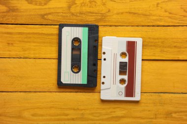 Sarı tahta tahtalardaki Retro 80 'lerin ses kasetleri. Üst görünüm