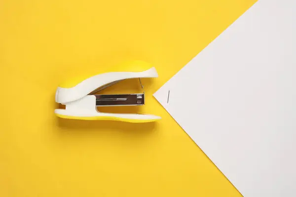 stock image Stapler with sheets of paper on a yellow background