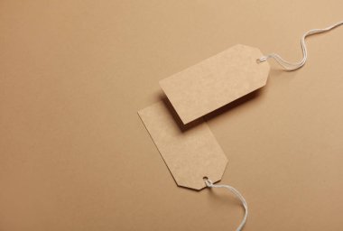 Bir dizgi üzerinde iki el işi fiyat etiketi, bej arkaplan