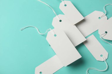 Mavi arka planda yüzen beyaz fiyat etiketlerinin bileşimi. Yaratıcı yerleşim