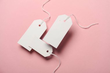 Pembe arka planda yüzen beyaz fiyat etiketlerinin bileşimi. Yaratıcı yerleşim