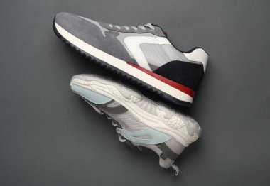 Koyu gri arka planda iki farklı koşu ayakkabısı.