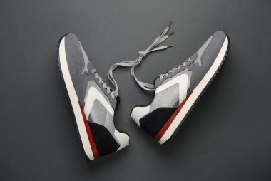 Siyah arka planda bağcıklı spor ayakkabılar.