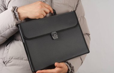 Elinde evrak çantası olan ceketli bir adam farkındalık kurdelesi tutuyor.