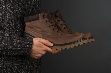 Deri çizmeli süveter giyen adam.