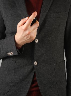 Elinde parfüm şişesi olan ceketli bir iş adamı.