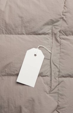 Kışları ceketin üzerinde beyaz boş bir etiket var. Alışveriş, satış konsepti. Tasarım şablonu
