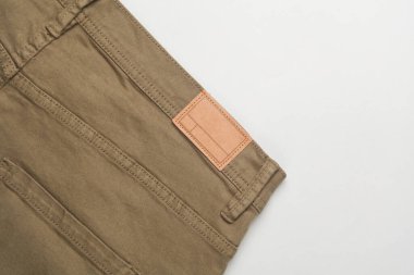 Beyaz arka planda boş deri etiketli pantolonlar.