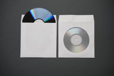 Koyu gri arkaplan üzerine kağıt paketlerdeki CD disklerin maketi
