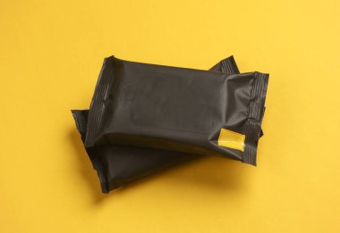 Sarı arkaplanda iki paket ıslak mendil.