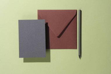 Üzerinde yeşil arka planda gölge olan davetiye olan yüzen bir zarf. Minimalizm, modern iş hayatı