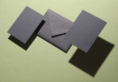 Üzerinde yeşil arka planda gölge olan davetiye olan yüzen bir zarf. Minimalizm, modern iş hayatı