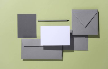 Yeşil arkaplanlı, gölgeli zarflar. Minimalizm, modern iş natürmort hayat, yaratıcı düzen