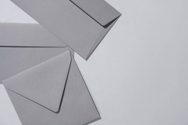 Gri arka planda gri zarflar. Minimalizm, modern iş natürmort hayat, yaratıcı düzen