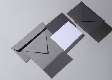 Gölgeli gri arka planda yüzen zarflar ve kartlar. Minimalizm, modern iş natürmort hayat, yaratıcı düzen