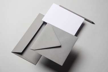 Gölgeli gri arka planda yüzen zarflar ve kartlar. Minimalizm, modern iş natürmort hayat, yaratıcı düzen