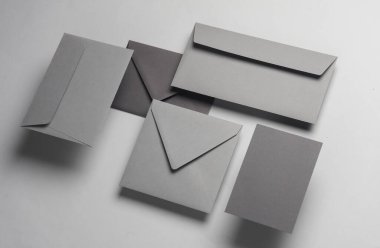 Gölgeli gri arka planda yüzen zarflar ve kartlar. Minimalizm, modern iş natürmort hayat, yaratıcı düzen