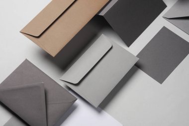 Gölgeli gri arka planda yüzen zarflar ve kartlar. Minimalizm, modern iş natürmort hayat, yaratıcı düzen