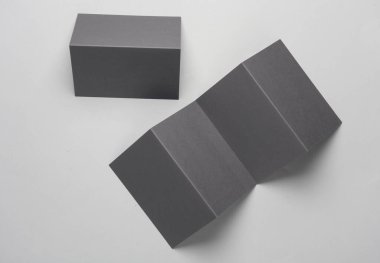 Gri arkaplanda üç ve çift katlı broşürler veya kart