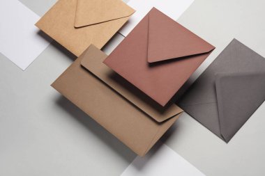 Gölgeli gri arka planda yüzen zarflar ve kartlar. Minimalizm, modern iş natürmort hayat, yaratıcı düzen