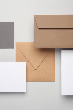 Gölgeli gri arka planda yüzen zarflar ve kartlar. Minimalizm, modern iş natürmort hayat, yaratıcı düzen