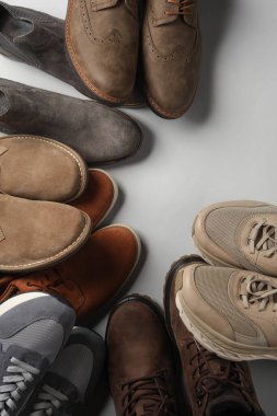 Gri arka planda farklı ayakkabılar. Boşluğu kopyala