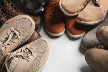 Gri arka planda farklı ayakkabılar. Boşluğu kopyala