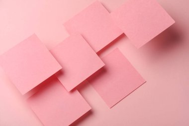 Pembe arka planda yüzen pembe kareli not kağıtlarının kompozisyonu. İş konsepti