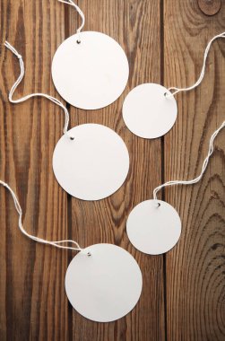 Ahşap zemin üzerinde dizgi beyaz boş yuvarlak etiketler