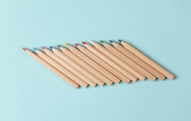 Mavi arka planda tahta renkli kalemler var. Yaratıcılık, sanat