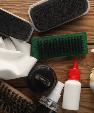 Ahşap arka planda ayakkabı bakım ürünleri ve aksesuarlar. Üst Manzara. Düz yatıyordu