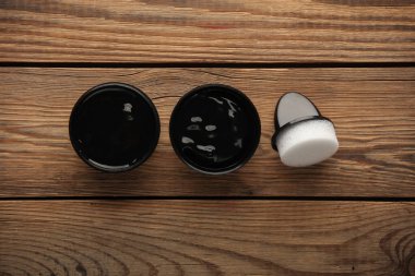 Ahşap arka planda süngerli ayakkabı cilası kavanozu. Üst görünüm