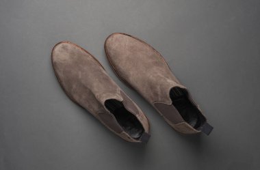 Koyu gri arka planda gri süet Chelsea botlar. Üst görünüm