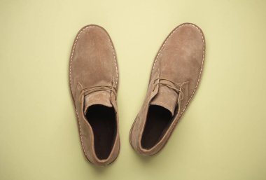 Bej yeşili arka planda süet çöl ayakkabıları. Üst görünüm