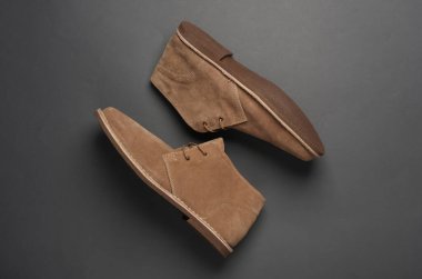 Koyu gri arka planda süet çöl çizmeleri. Üst görünüm