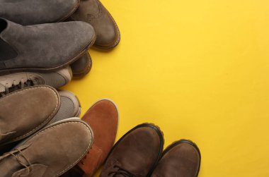 Sarı arka planda farklı erkek ayakkabıları. Üst Manzara. Boşluğu kopyala