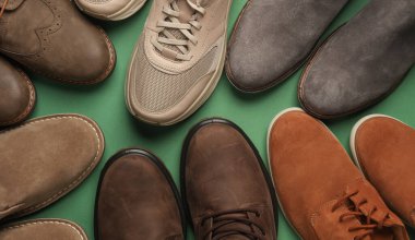 Yeşil arka planda farklı erkek ayakkabıları. Üst görünüm