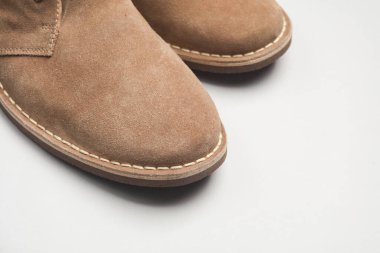 Beyaz arka planda süet çöl çizmeleri.