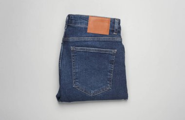 Gri arka planda katlanmış mavi kot pantolon. Üst görünüm