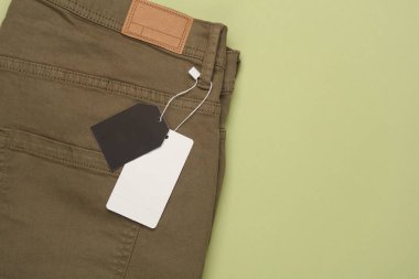 Bir dizgi üzerinde etiketli pantolon, yeşil arkaplan