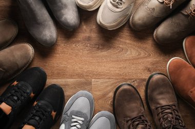 Ahşap zeminde farklı ayakkabılar var. Üst Manzara. Boşluğu kopyala