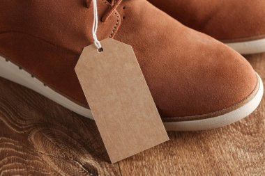 İpin üzerinde etiket olan bir çift süet ayakkabı. Moda, satış konsepti