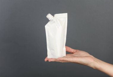 Elinde şeker kutusu olan, koyu gri arka planda beyaz bir köpek. Tasarım için şablon, model